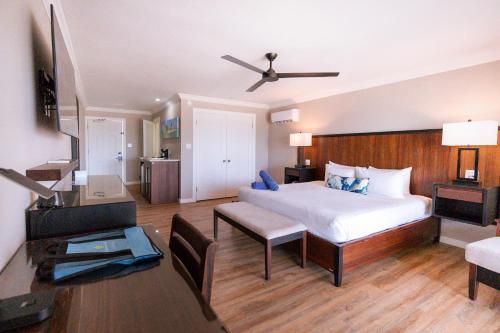 a bedroom with a bed and a desk and a television at St. James's Club Resort - All Inclusive in English Harbour Town