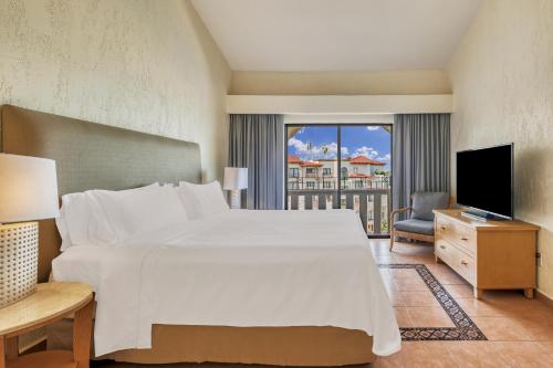 a bedroom with a large white bed and a television at Fiesta Americana Cancun Villas in Cancún