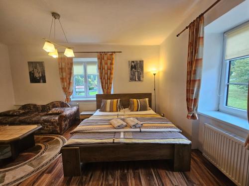 a living room with a bed and a couch at Pension Pod Lipou in Loučovice