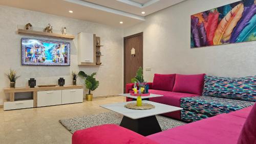 a living room with a pink couch and a table at Luxury 3 Bedroom Apartment with Private Suite and Terrace in Casablanca