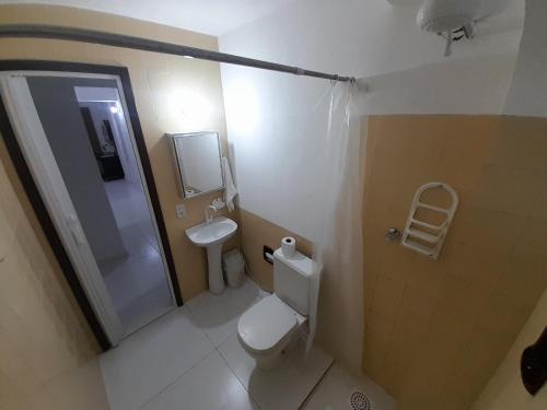 a small bathroom with a toilet and a sink at Casa com saída p/ praia do Peró Cabo Frio in Peró