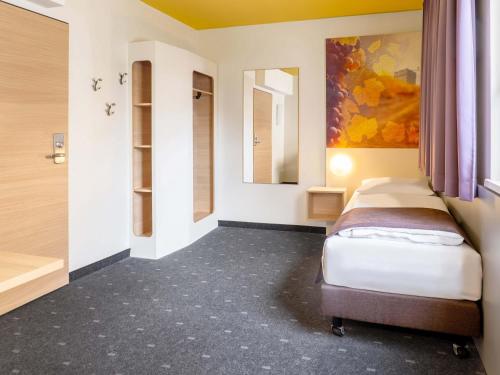a small room with two beds and a bathroom at B&B Hotel Heilbronn in Heilbronn