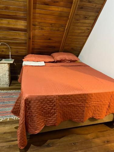 - un lit avec une couette en orange dans l'établissement Canto Gira Sol - Estúdio Borboleta, à Penha
