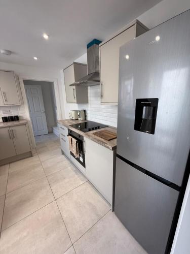 a kitchen with white cabinets and a refrigerator at ResiLets Barnard St NEW Large 4 Bed House, Contractor Stays, Central in Blythe