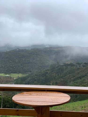 a wooden table with a view of a mountain at Chalé Alto do Morro 2 - conforto e vista deslumbrante in Rancho Queimado