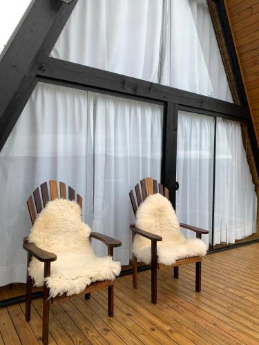 two chairs with furry cushions sitting in front of a window at Chalé Alto do Morro 2 - conforto e vista deslumbrante in Rancho Queimado