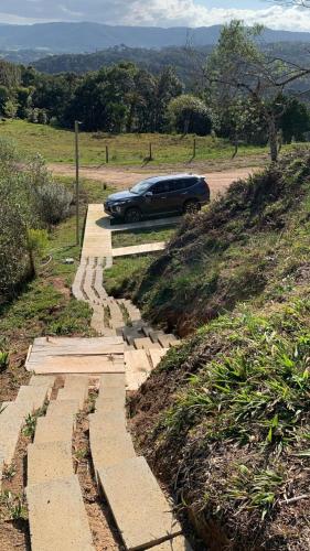 a car parked on a road next to a hill at Chalé Alto do Morro 2 - conforto e vista deslumbrante in Rancho Queimado