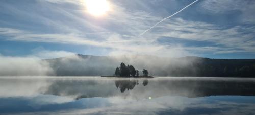 a view of a lake with the sun in the sky at Pension Pod Lipou in Loučovice