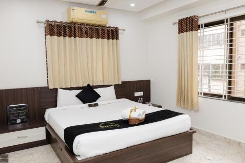 a bedroom with a large bed with white sheets at Reunion Aaradhya Villa in Udupi