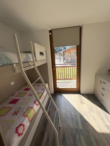 a bedroom with a bunk bed and a sliding glass door at Residenza Viola in Valdidentro