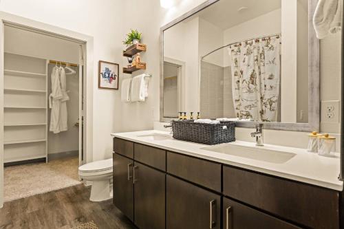 a bathroom with a sink and a toilet and a mirror at Lookout Luxe 2BR | Shuffleboard | Classy | 1GB in Dallas