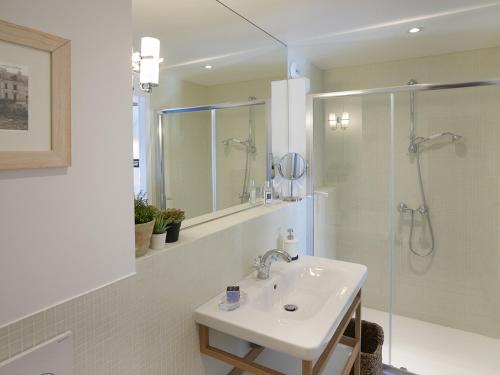 un bagno bianco con lavandino e doccia di Studio moderne avec vue mer et port à Sauzon, 2* - FR-1-418-190 a Sauzon