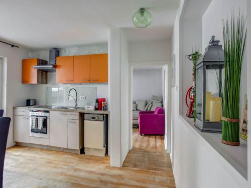 a kitchen with white cabinets and a pink chair at Apartment Feld am See near Ski Slopes in Feld am See