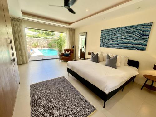 - une chambre avec un lit et une grande peinture murale dans l'établissement Bangtao villa with pool & rooftop terrace, à Ban Thalat Choeng Thale
