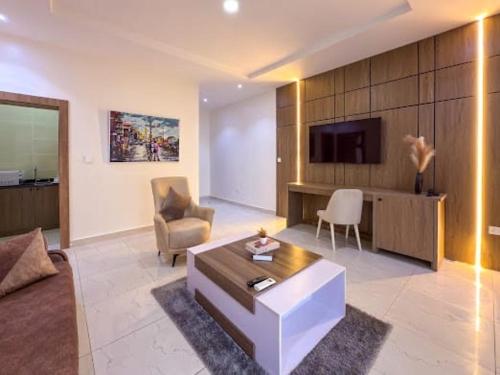 a living room with a couch and a tv at NA Conference Centre And Suite in Karsana