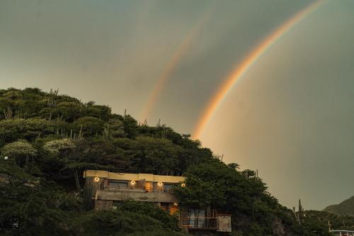 a double rainbow over a house on a hill at Perla Roca Hotel Boutique - Beach Front in Santa Marta