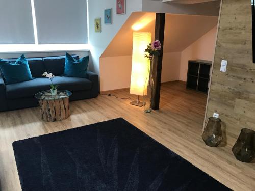 a living room with a couch and a table with flowers at Hotel Heddernheimer Hof in Frankfurt/Main
