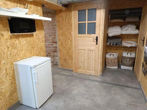 una nevera blanca en una habitación con puerta en Room 1 industrial, en Cracovia