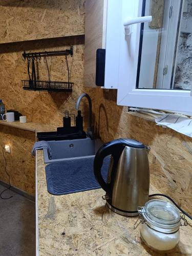 a kitchen counter with a tea kettle and a sink at Room 1 industrial in Krakow