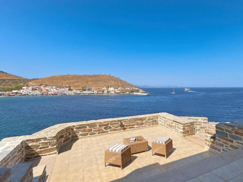 two chairs and a table on a patio overlooking the water at KEOS by the sea in Korissia