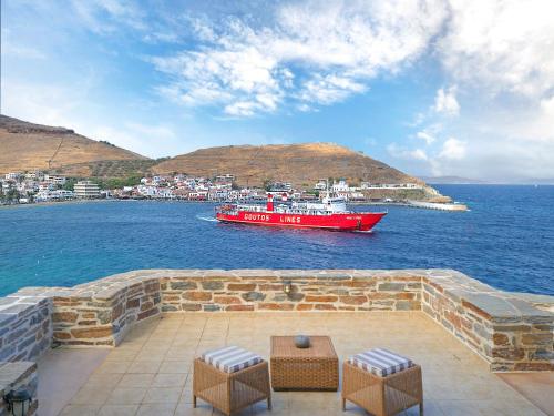a red boat in the water with a city at KEOS by the sea in Korissia