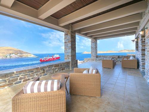 a patio with a view of the ocean and a boat at KEOS by the sea in Korissia