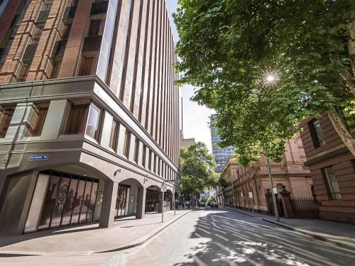 an empty street in a city with tall buildings at Mantra on Little Bourke Melbourne in Melbourne