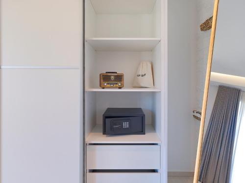 a closet with a microwave and a radio in it at KEOS by the sea in Korissia