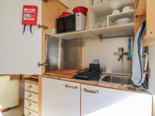 a kitchen with a sink and a microwave at Over Village Studio in Over