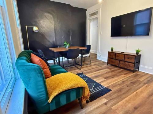 a living room with a green couch and a table at Short North Convention Private Parking Pets! in Columbus