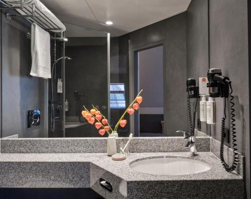 a bathroom with a sink and a large mirror at Flemings Hotel Frankfurt-Central in Frankfurt/Main