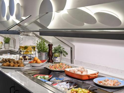 a kitchen with many plates of food on a counter at Flemings Hotel Frankfurt-Central in Frankfurt/Main