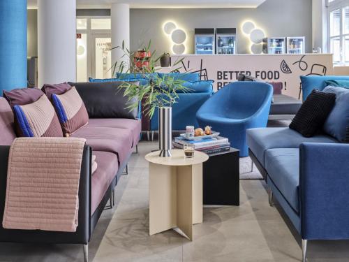 a store with blue and pink couches and a table at Flemings Hotel Frankfurt-Central in Frankfurt/Main
