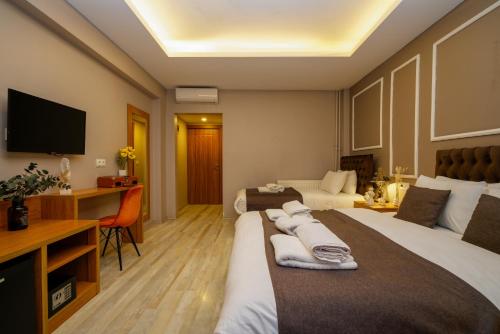 Una habitación de hotel con dos camas y un televisor. en Luxery Hanpoint Hotel, en Estambul