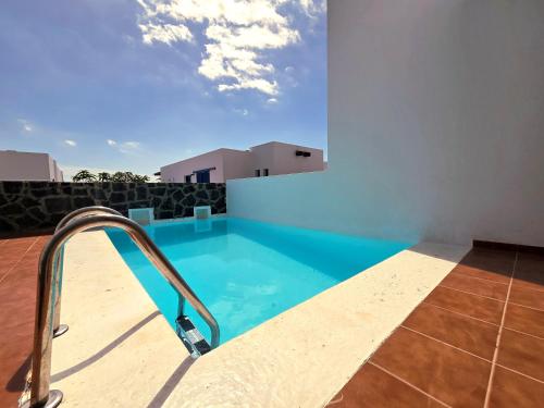 Una piscina en medio de un edificio con cielo. en Villa Papagayo Mirage, en Playa Blanca