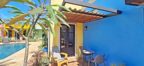 a blue house with a palm tree and a table and chairs at Club Heasa - Men Only in La Garita
