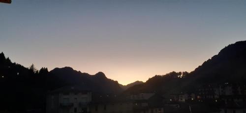 a sunset over a city with mountains in the background at Eden Apartment di Manenti Andrea in Oltre il Colle