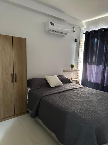 a bedroom with a bed and a cabinet and a window at Apartamento con vista al mar in Tucacas
