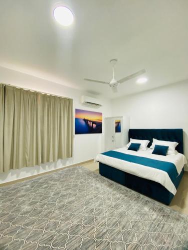 a bedroom with a large bed with blue and white sheets at VIP Room13 in South alhail - Muscat in Ḩayl Āl ‘Umayr