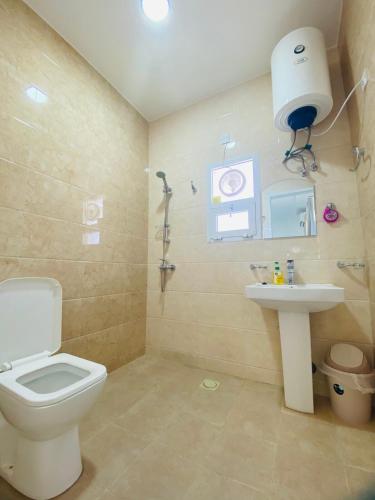 a bathroom with a toilet and a sink at VIP Room13 in South alhail - Muscat in Ḩayl Āl ‘Umayr