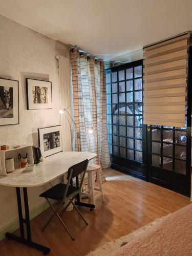 a dining room with a table and chairs and a window at Chambre chez l'habitant in Grenoble
