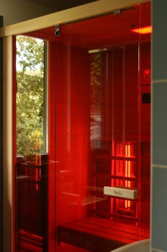 a red bathroom with a window and a red wall at Mirtusz Vendégház in Verőce