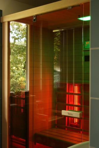 a bathroom with a glass wall with a bench in it at Mirtusz Vendégház in Verőce