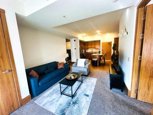 a living room with a blue couch and a table at 3BR King Bed Chamber Apartment at The Grand Castle in Grandville