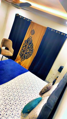 a bedroom with a bed with a curtain and a chair at 2bed available in Islamabad in Lower Topa