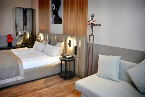 a hotel room with a bed and a couch at Arthotel Munich in Munich