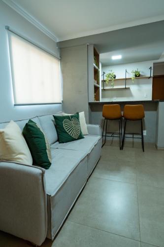 a living room with a couch and two chairs at Terraço Flat Hotel in Dourados