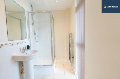 a white bathroom with a sink and a shower at Charming 2-Bed Apt - Close to amenities - Sleep 6 in Watford West Station