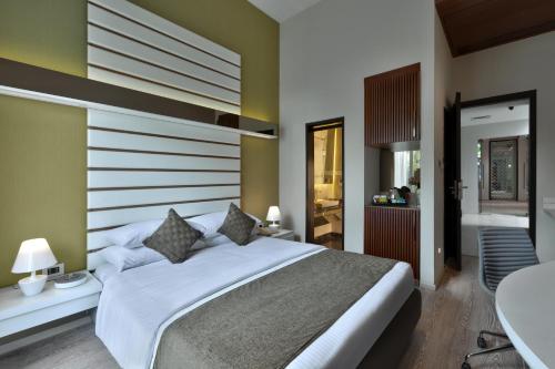 a bedroom with a large white bed and a bathroom at The Atara Near Golf Course Road in Gurgaon