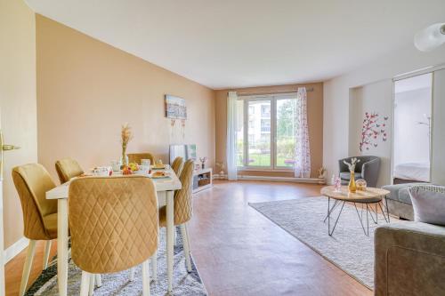 ein Wohnzimmer mit Tisch und Stühlen in der Unterkunft Cocon Roseraie in LʼHay-les-Roses